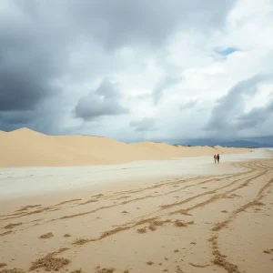 Eroded Coronado beach with exposed sand dunes and stormy sky.