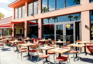 Outdoor dining setup at a California restaurant with open windows and doors.